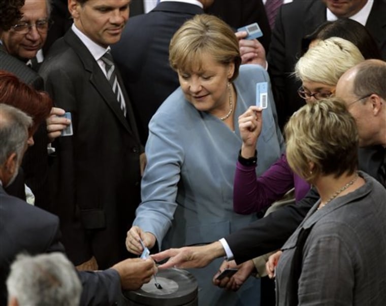 German Chancellor Angela Merkel casts her vote after a debate about the future of nuclear power at the German Federal Parliament, Bundestag, in Berlin, Germany, Thursday, June 30, 2011. 